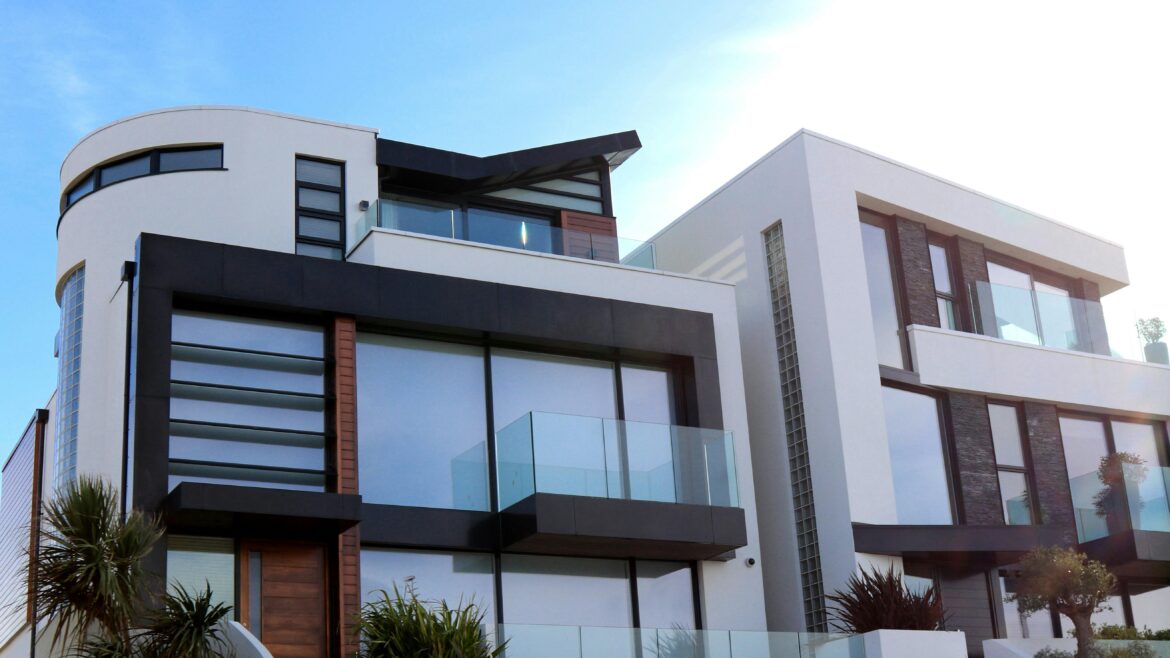 Photo of modern architectural style condos, perfect for investors or Airbnb owners looking to add a new rental, with palm trees against a clear blue sky with clouds.