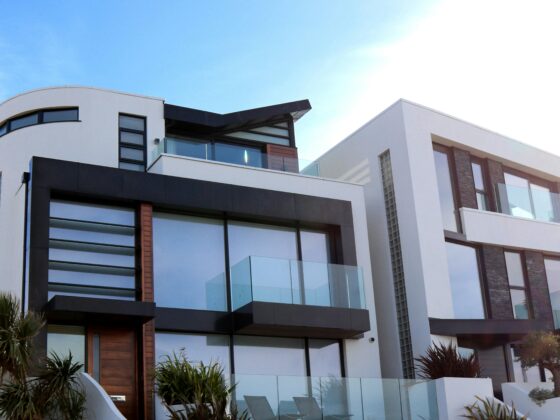 Photo of modern architectural style condos, perfect for investors or Airbnb owners looking to add a new rental, with palm trees against a clear blue sky with clouds.