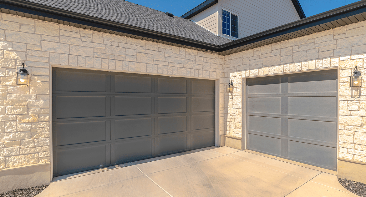 Two-car garage with stone facade and driveway
