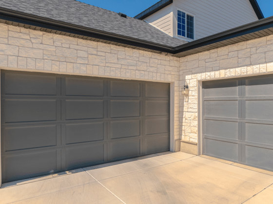 Two-car garage with stone facade and driveway